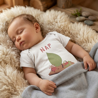 Baby wearing the NAP bodysuit in white (6–18 months) with hand-drawn illustration by Justmimmi