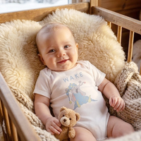 Baby wearing the WAKE bodysuit in white (6–18 months) with hand-drawn illustration by Justmimmi